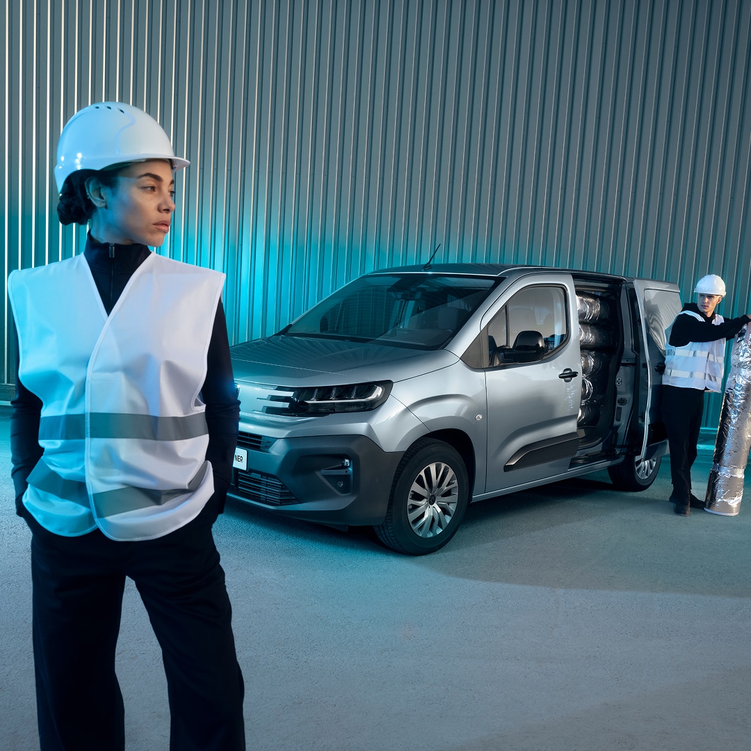 Frau vor einem PEUGEOT E-Partner stehend