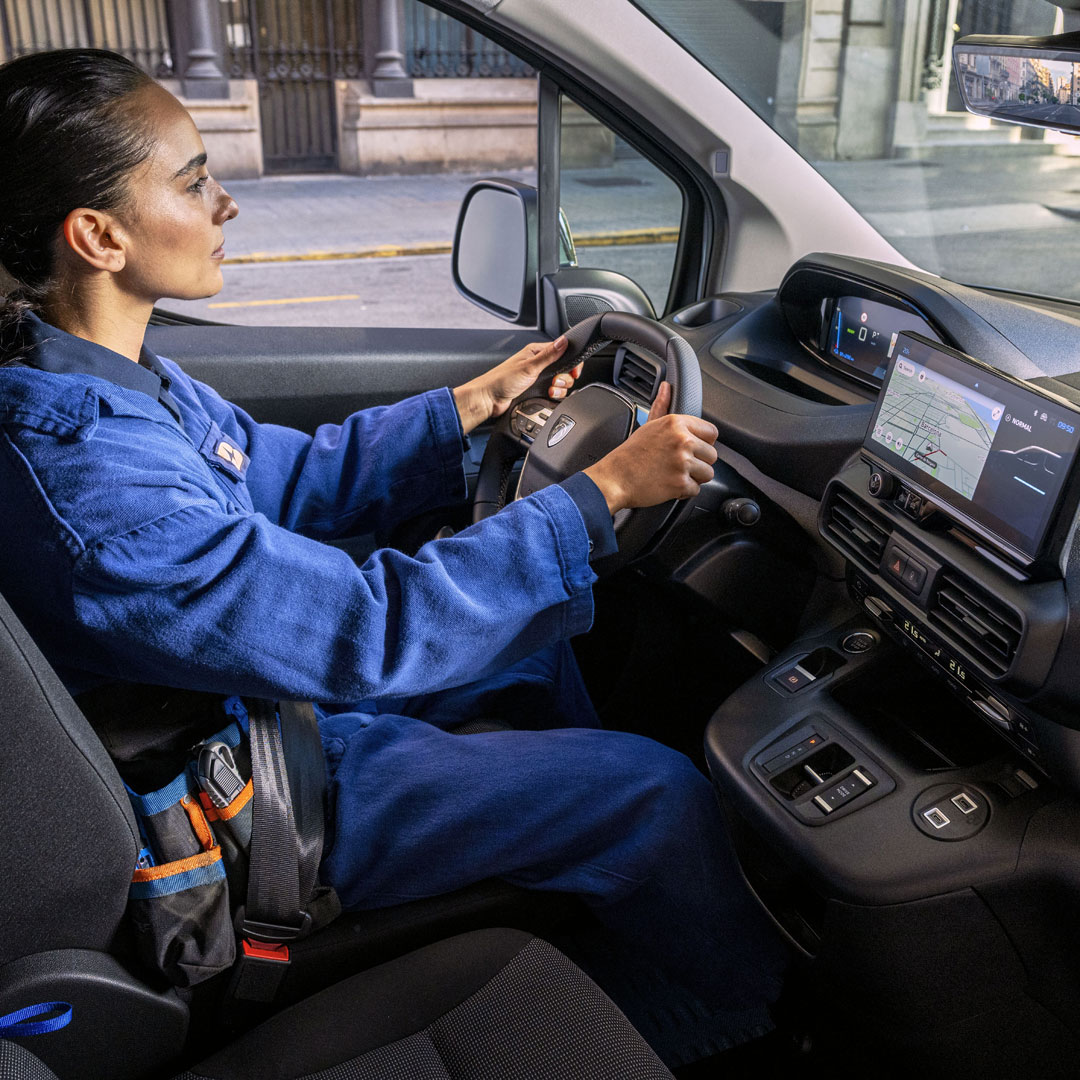 Frau am Steuer des PEUGEOT E-Partner mit 10-Zoll-Display des PEUGEOT i-Cockpit®