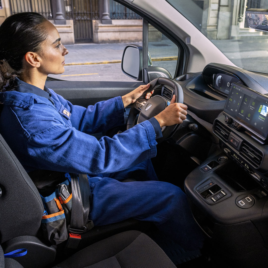 Frau am Steuer des PEUGEOT Partner mit 10-Zoll-Display PEUGEOT i-Cockpit®